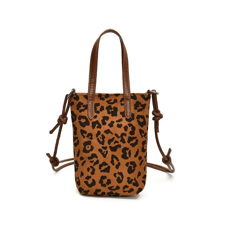 Leopard print mini crossbody bag with brown handles and adjustable side straps on white background