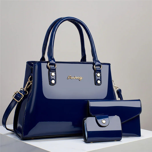 Navy blue patent leather handbag set with tote, envelope clutch, and wallet on display