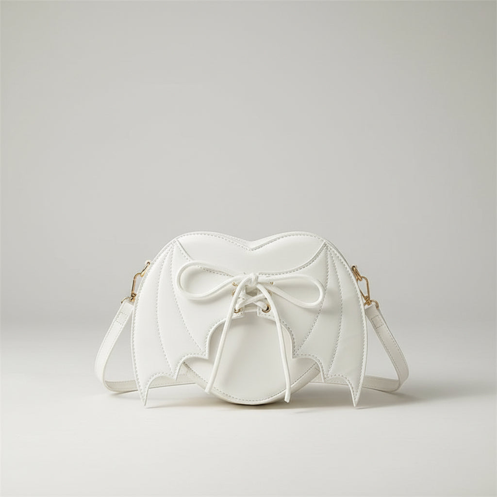 White bat wing crossbody bag with lace-up front, displayed on denim jeans