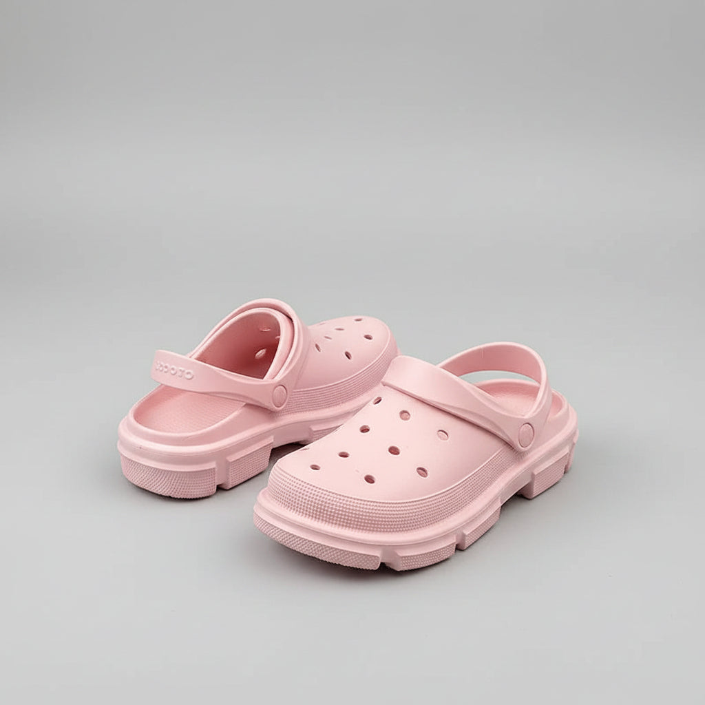 Light pink slip-on clogs with ventilation holes, foam material, on wooden table