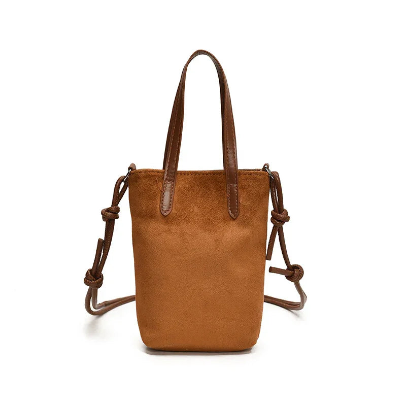 Brown suede mini tote bag with shoulder strap and top handles on white background